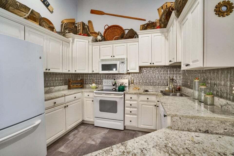 a kitchen with stainless steel appliances granite countertop a sink a stove and cabinets