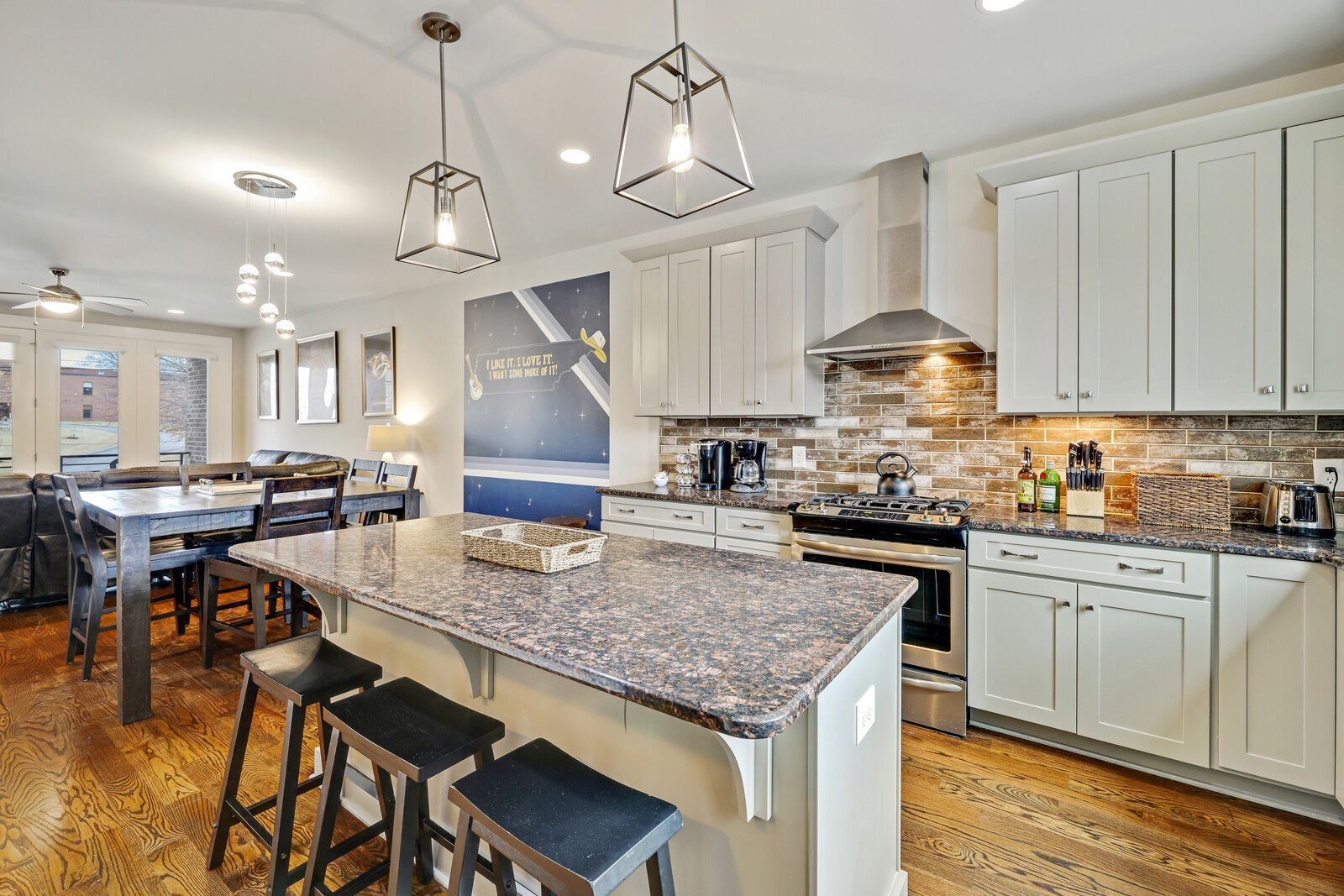 a kitchen with kitchen island granite countertop a table chairs sink and cabinets