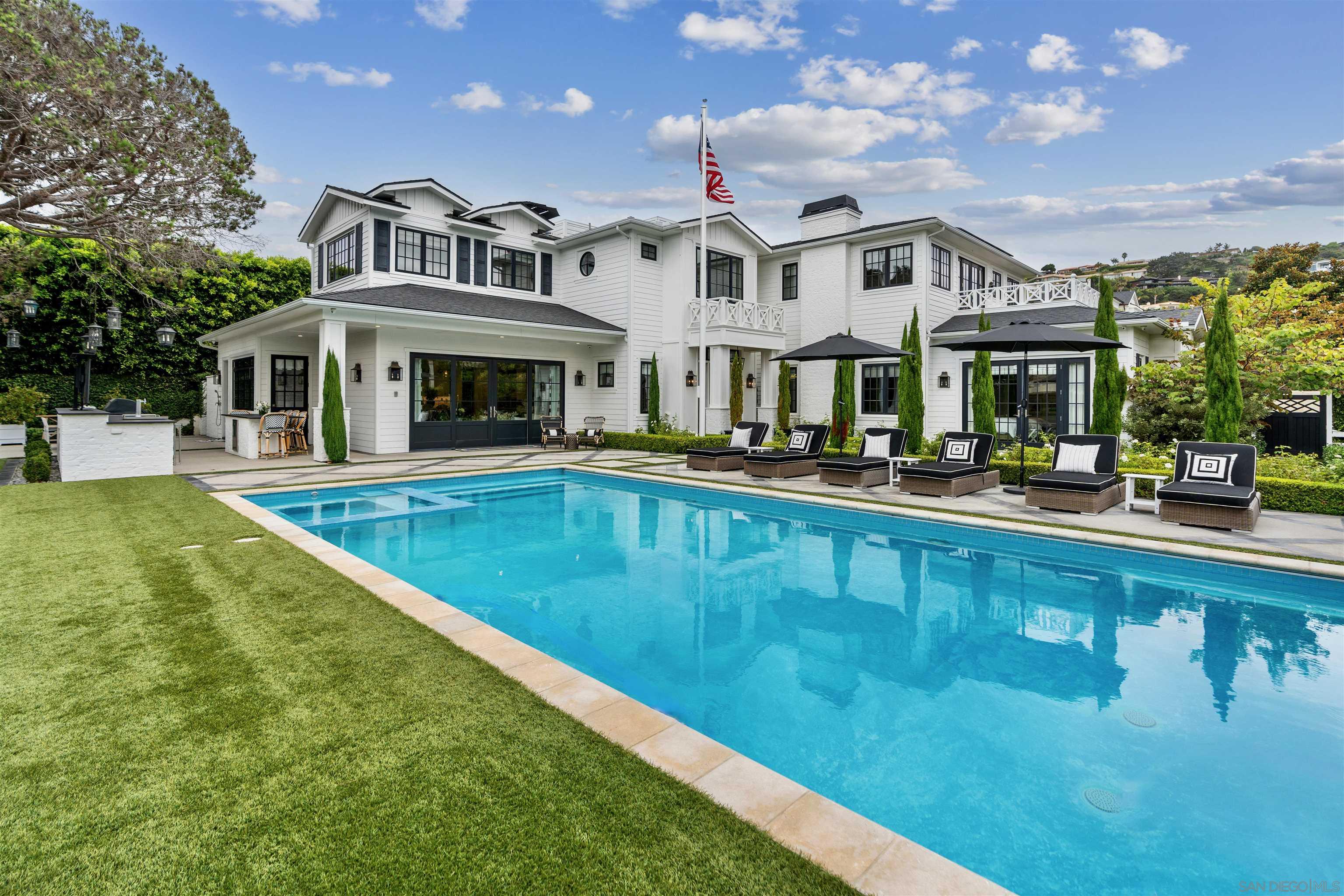 a view of an house with swimming pool and chairs