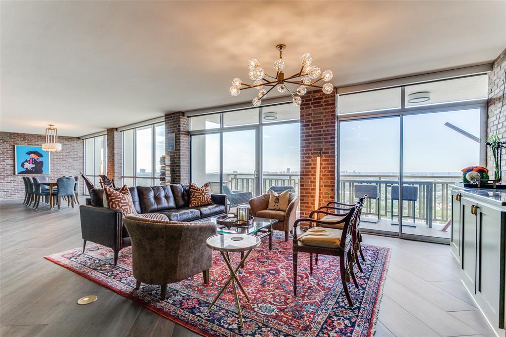 a living room with furniture a large window and a chandelier