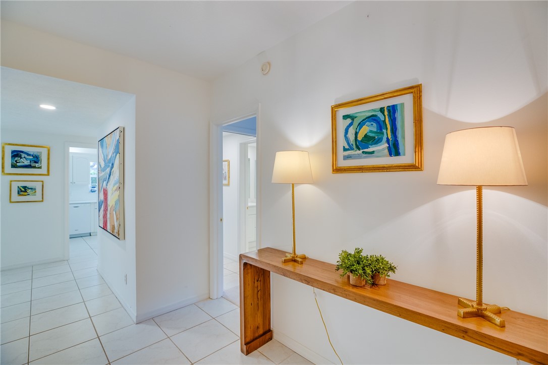 a hallway with painting and a potted plant