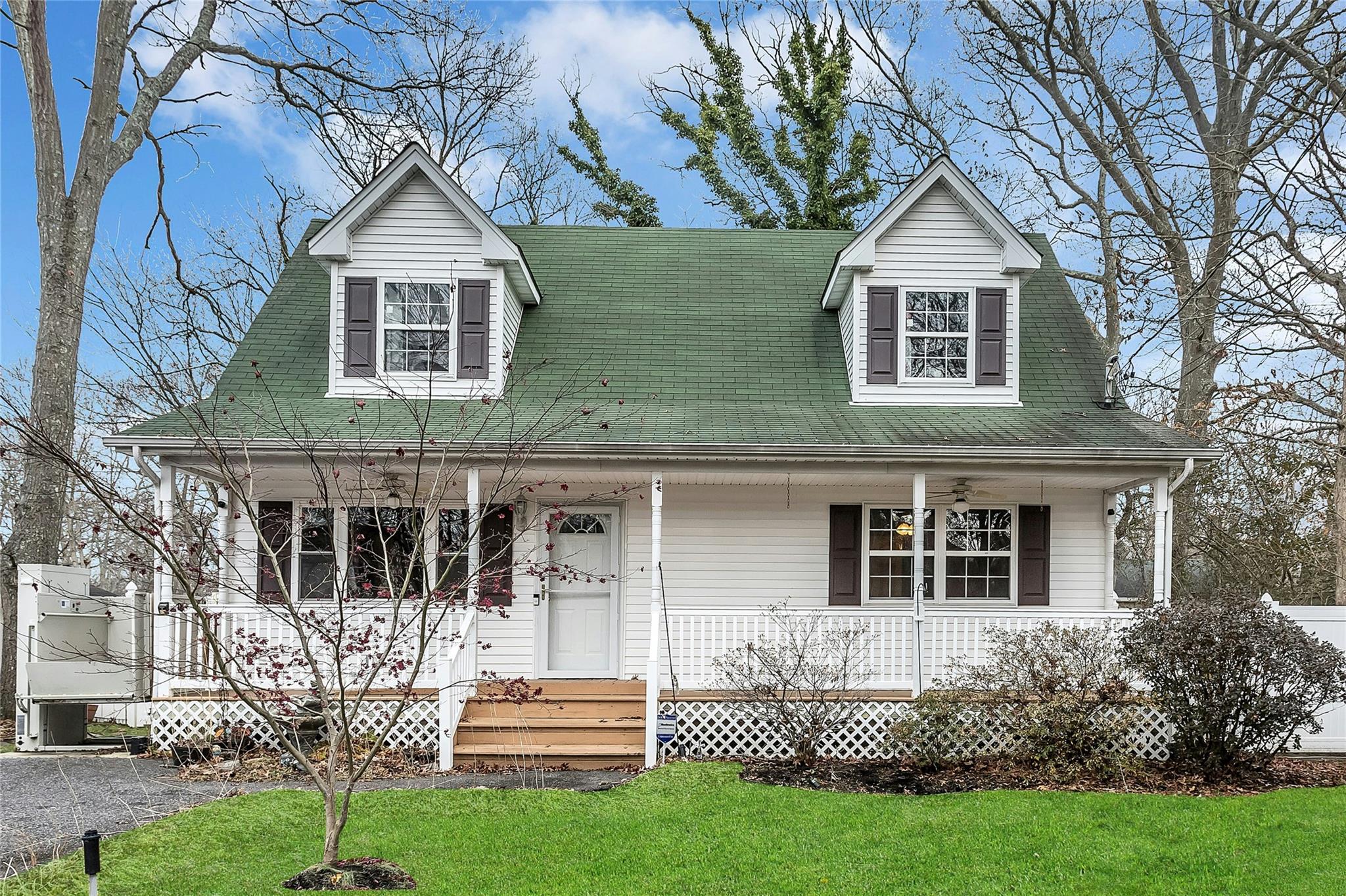 View of front of home with covered porch and a front lawn