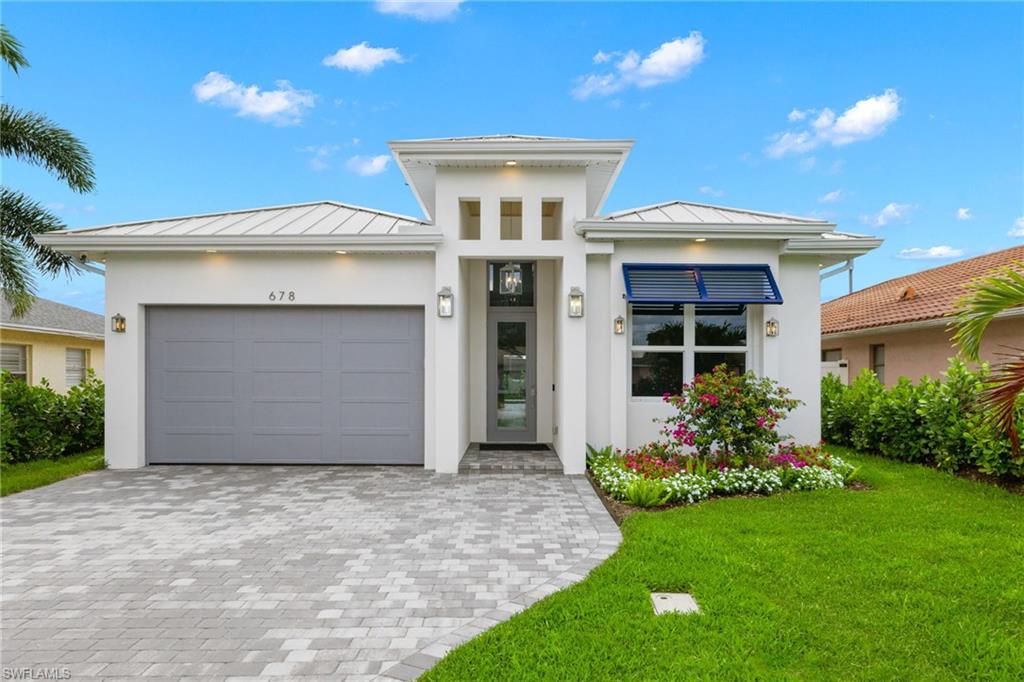 View of front of home featuring a front lawn and a garage