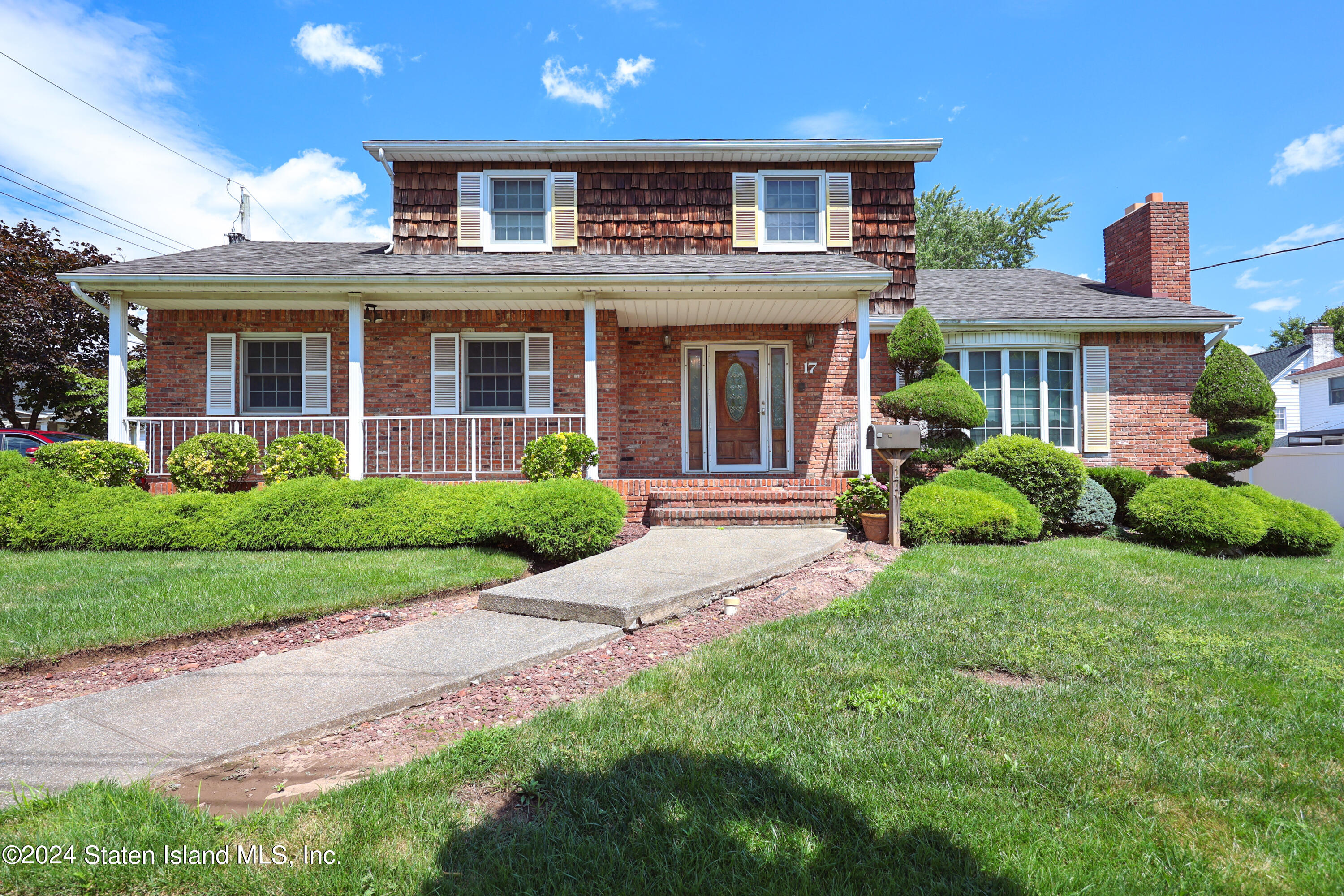 front view of a brick house with a yard