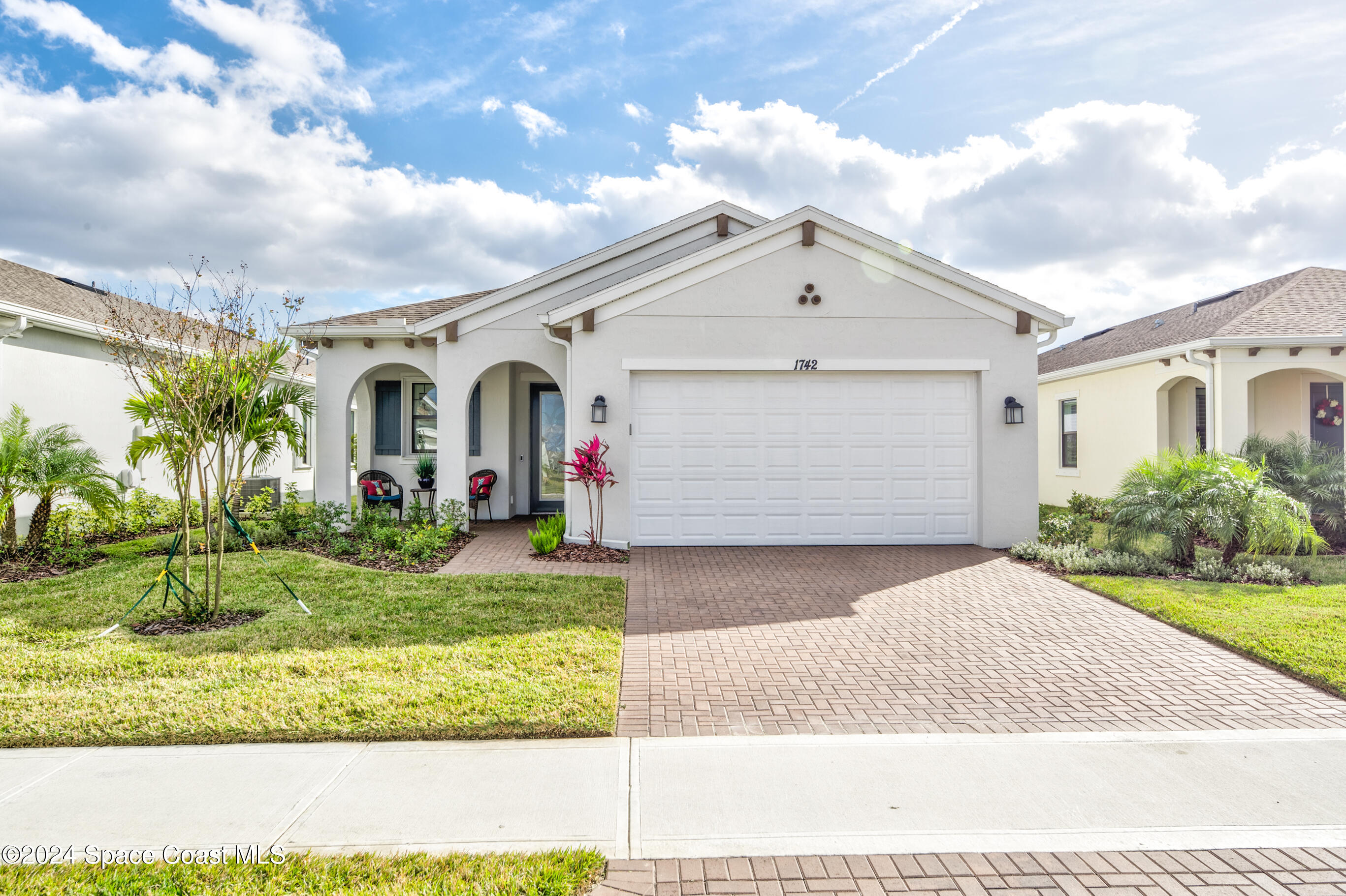 a front view of a house with a yard and garage