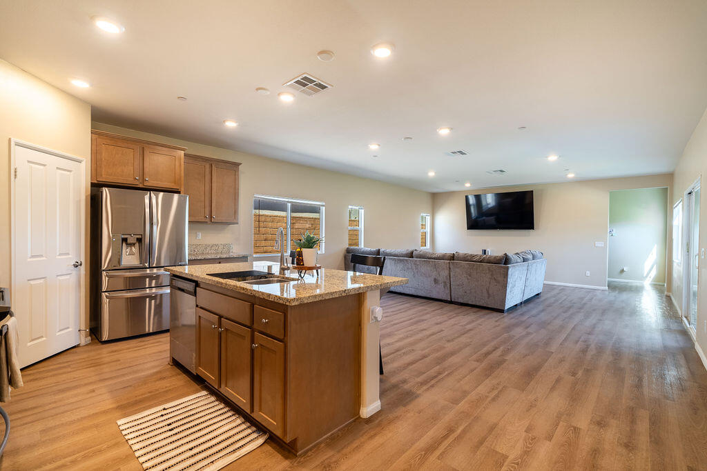 a kitchen with stainless steel appliances kitchen island granite countertop a stove and a refrigerator