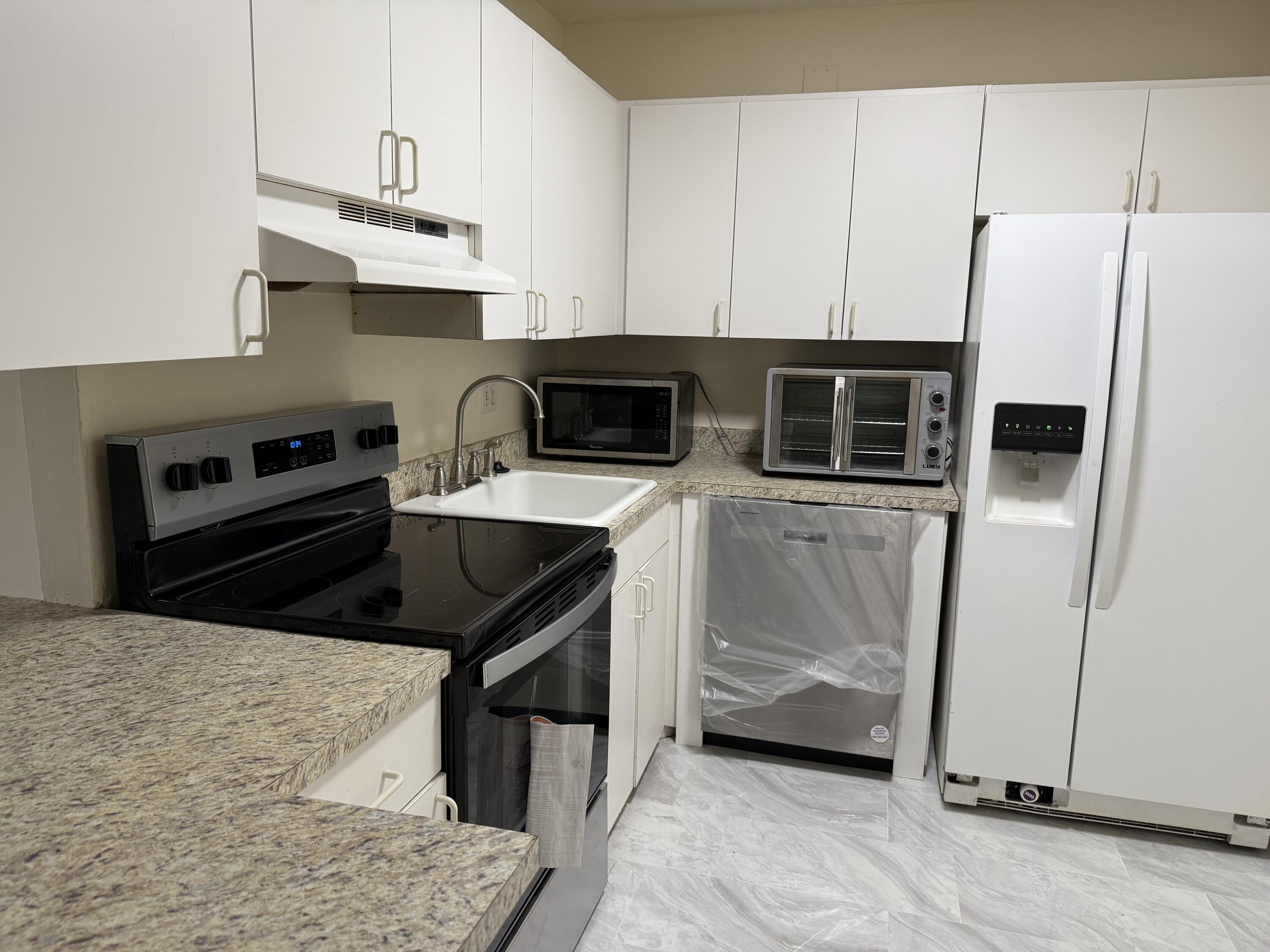 a kitchen with stainless steel appliances a stove a sink a microwave and cabinets