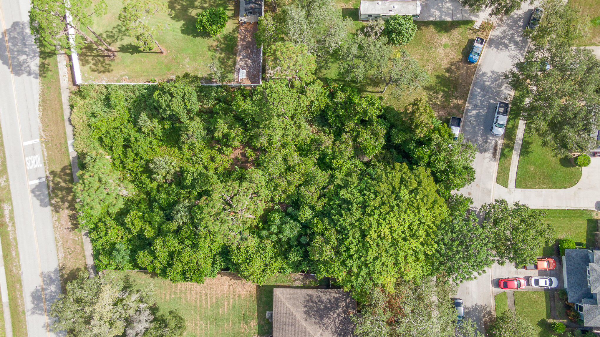 an aerial view of residential house with outdoor space and trees all around