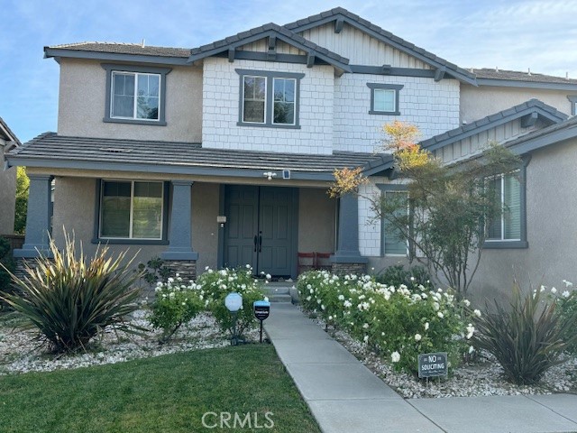 a front view of a house with a garden