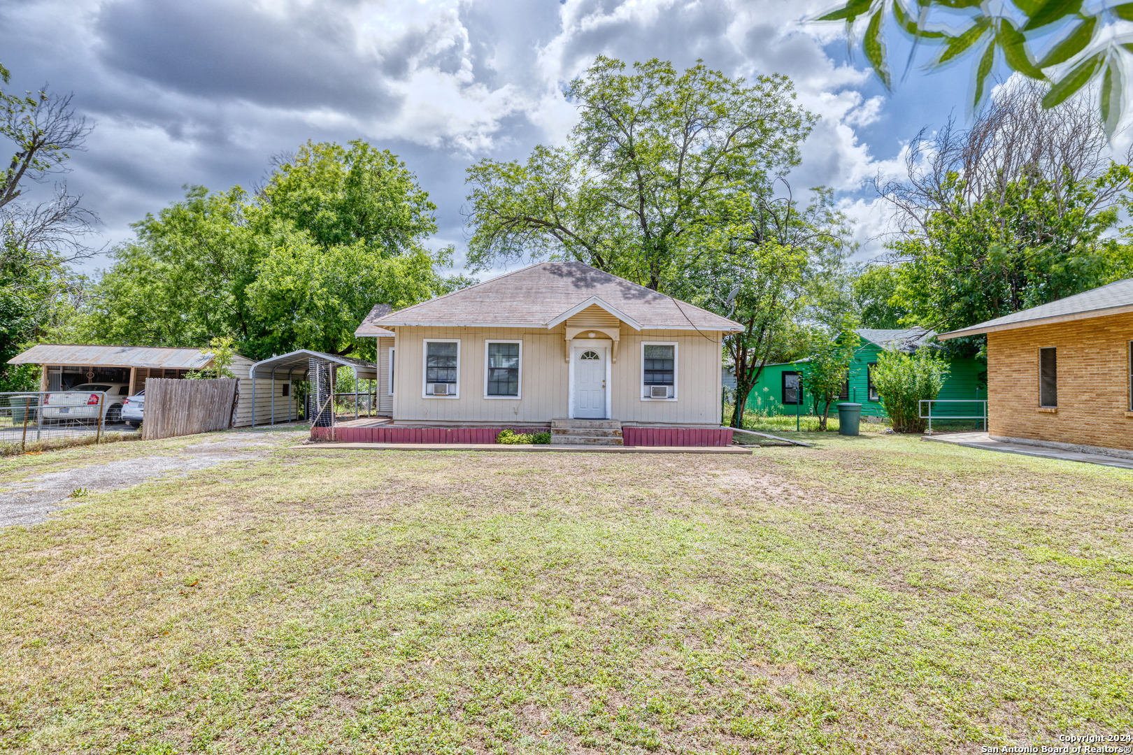 a front view of a house with yard and trees