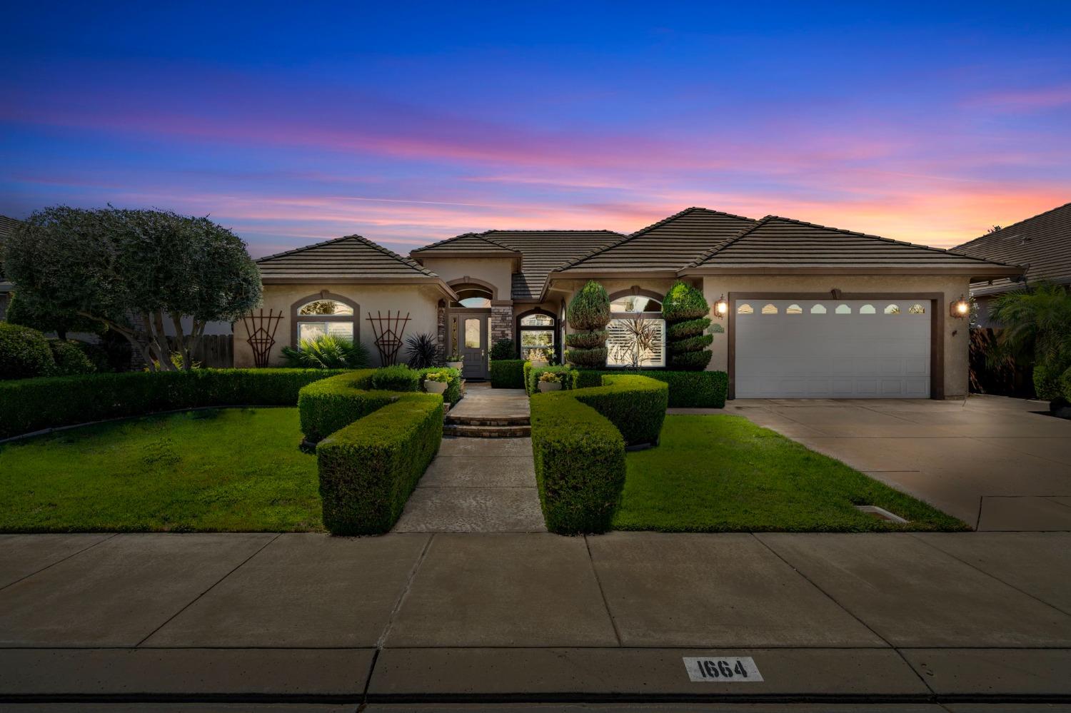 a front view of a house with a garden