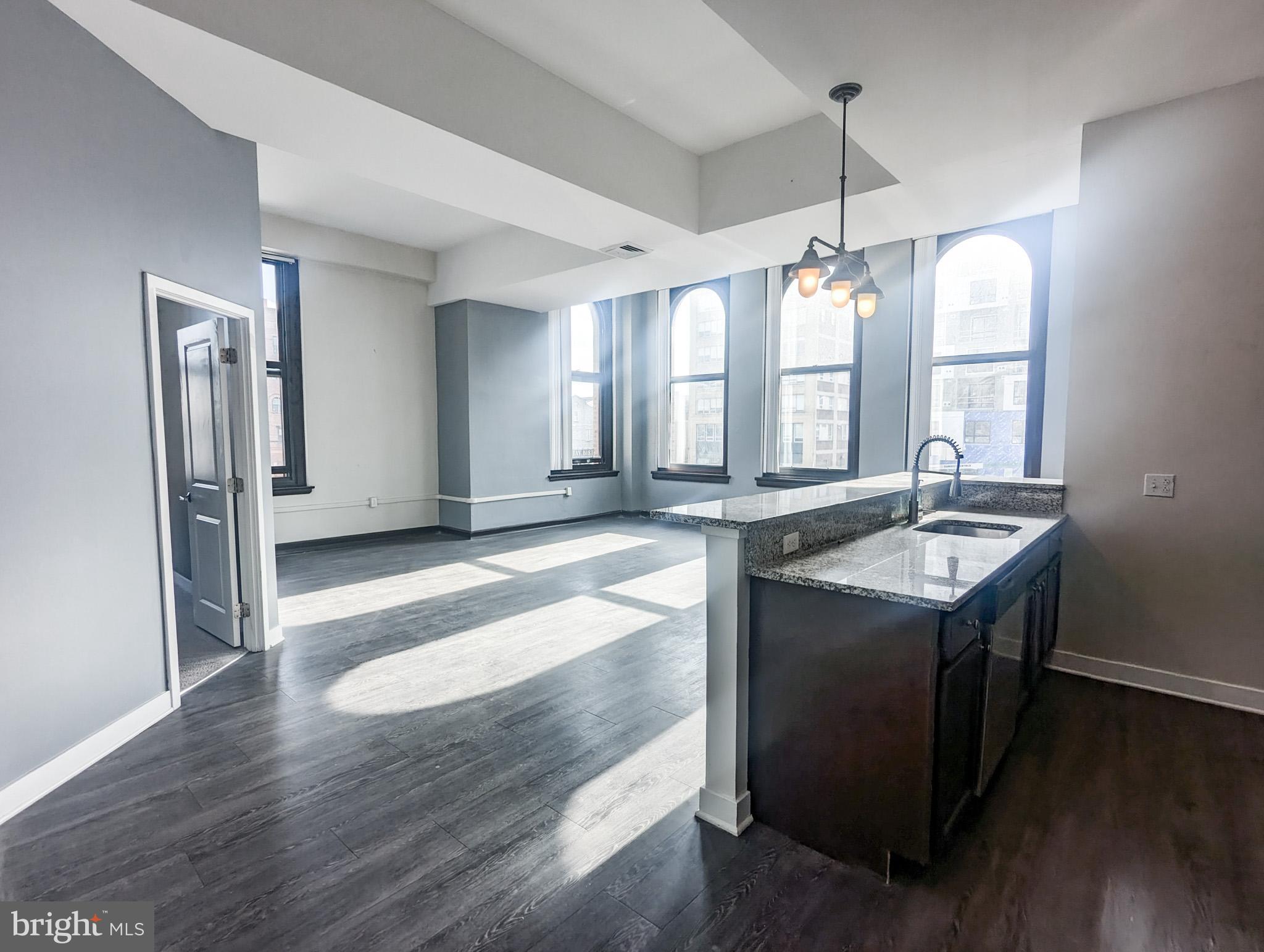 a kitchen with stainless steel appliances granite countertop a sink stove and wooden floor