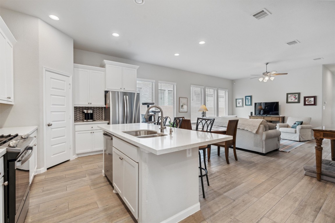 a large kitchen with kitchen island a sink table and chairs