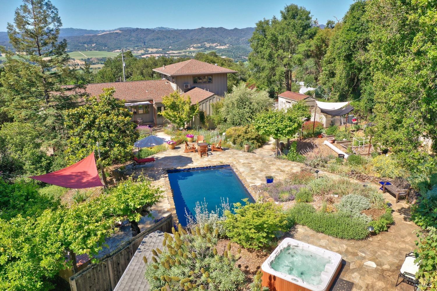 an aerial view of a house with a garden and mountains