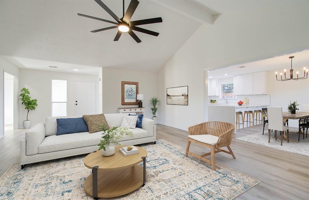 a living room with furniture and view of kitchen