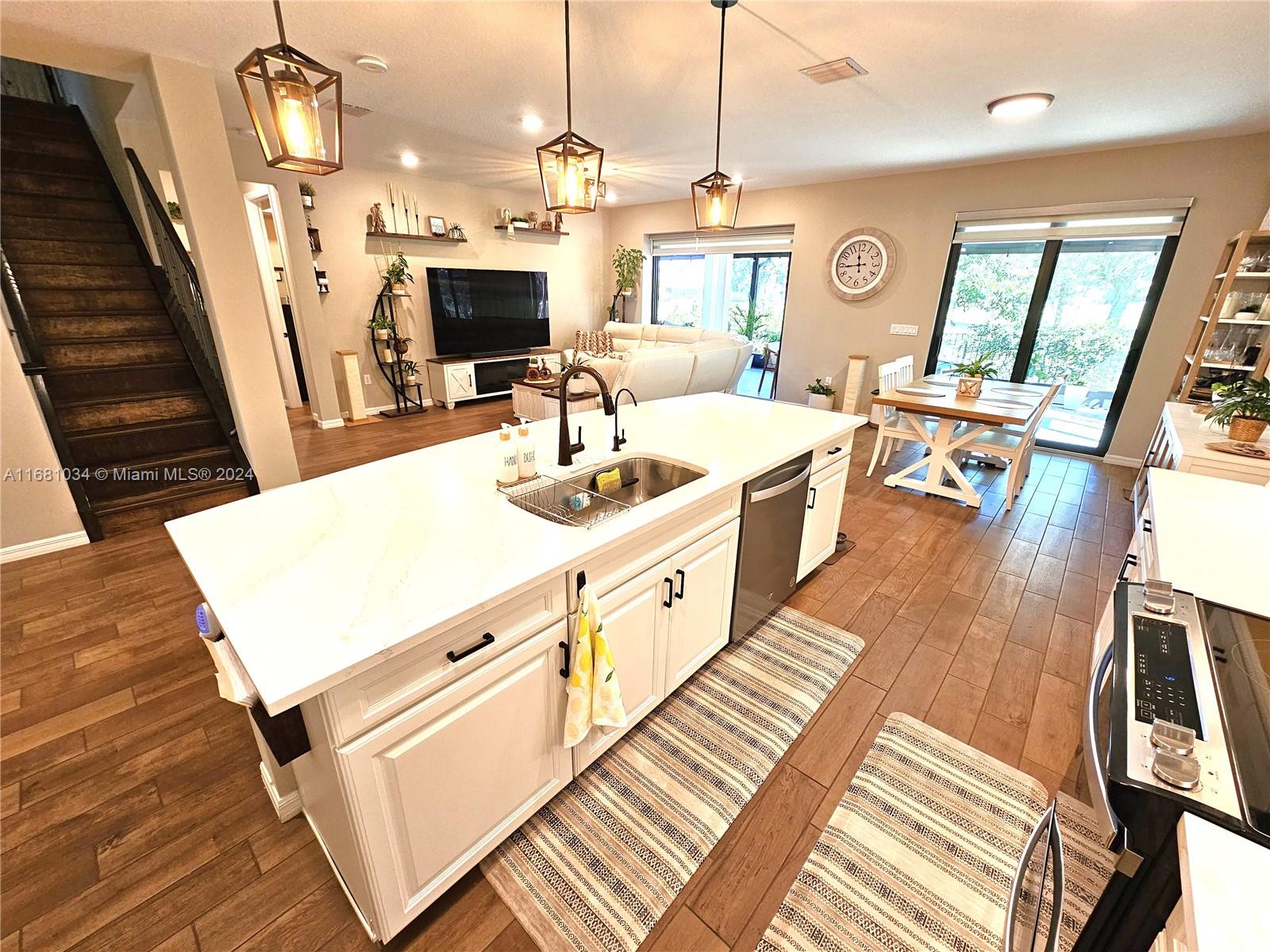 a large white kitchen with wooden floor