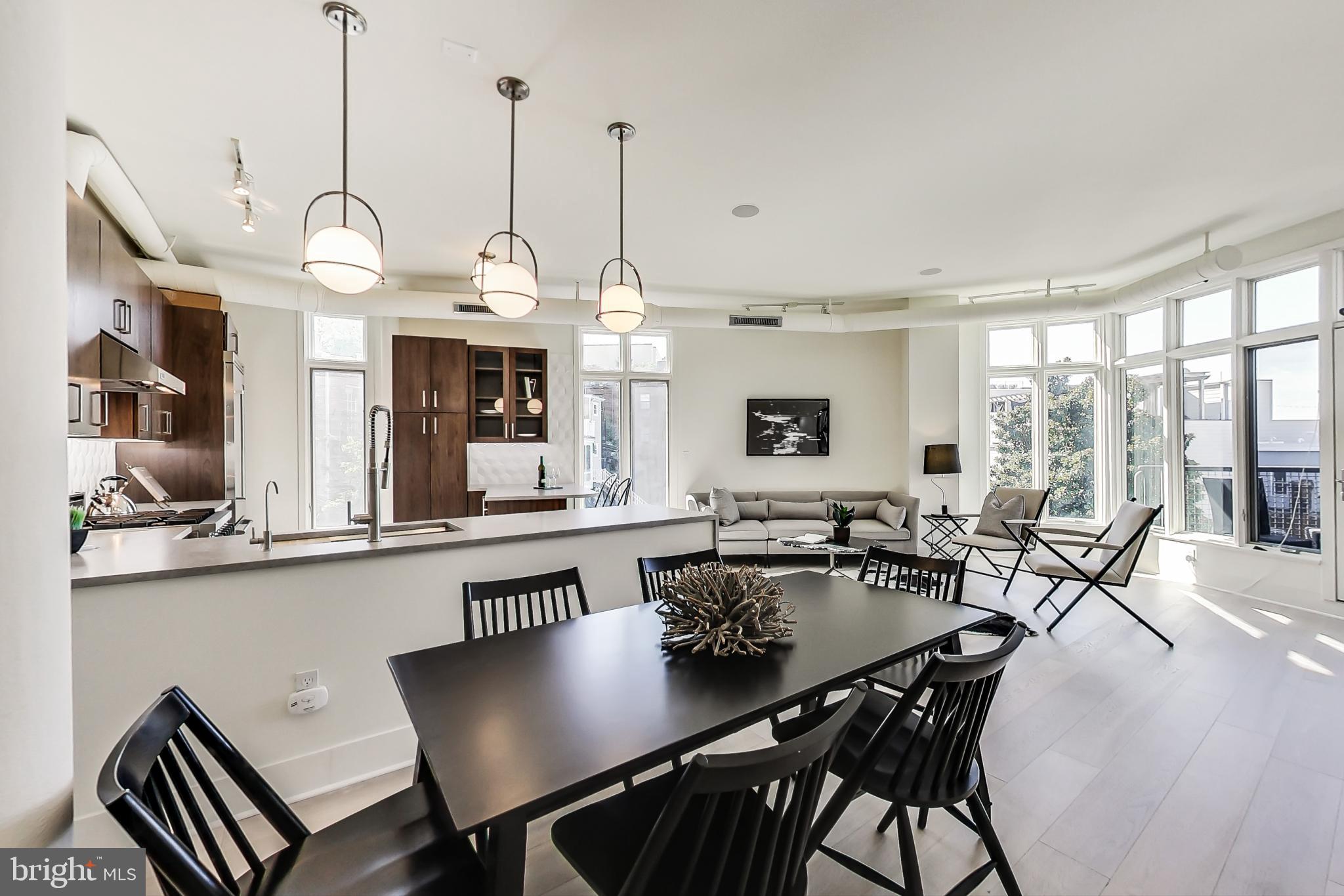 a view of a dining room and livingroom with furniture wooden floor a chandelier