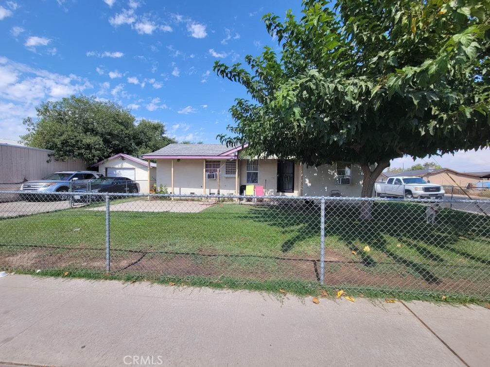 a view of a house with a backyard and a tree