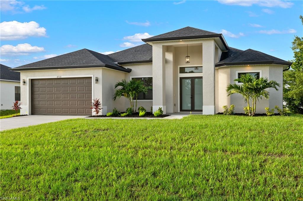 Front view of property with front lawn and a 2 car garage