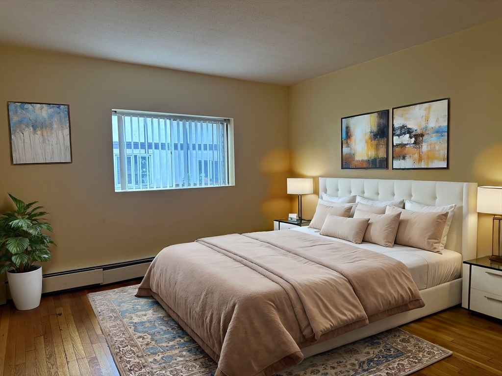 a bedroom with bed and wooden floor