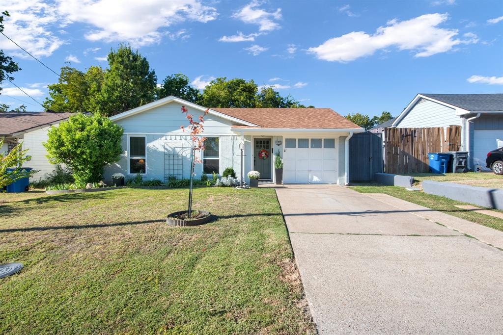 Ranch-style home with a front lawn and a garage