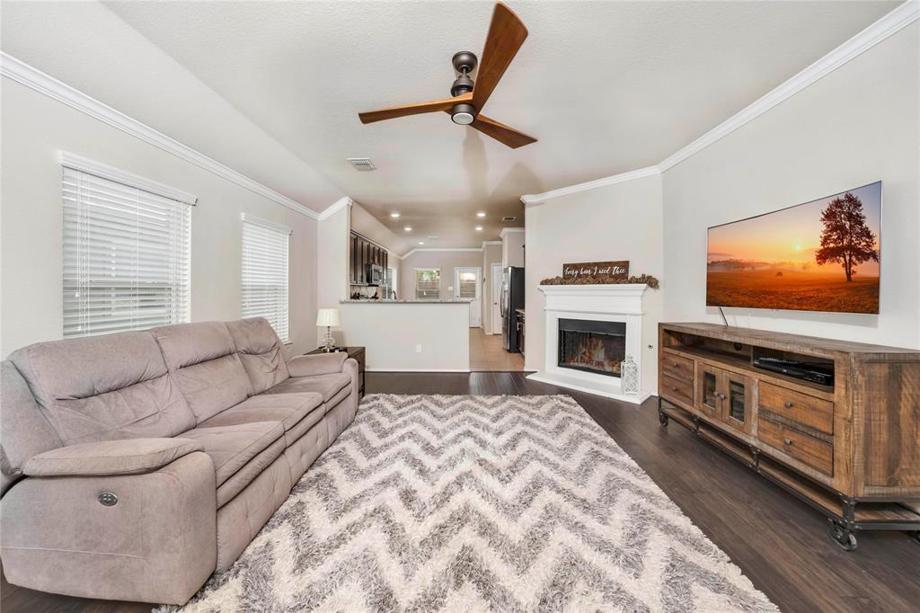 a living room with furniture a flat screen tv and a fireplace