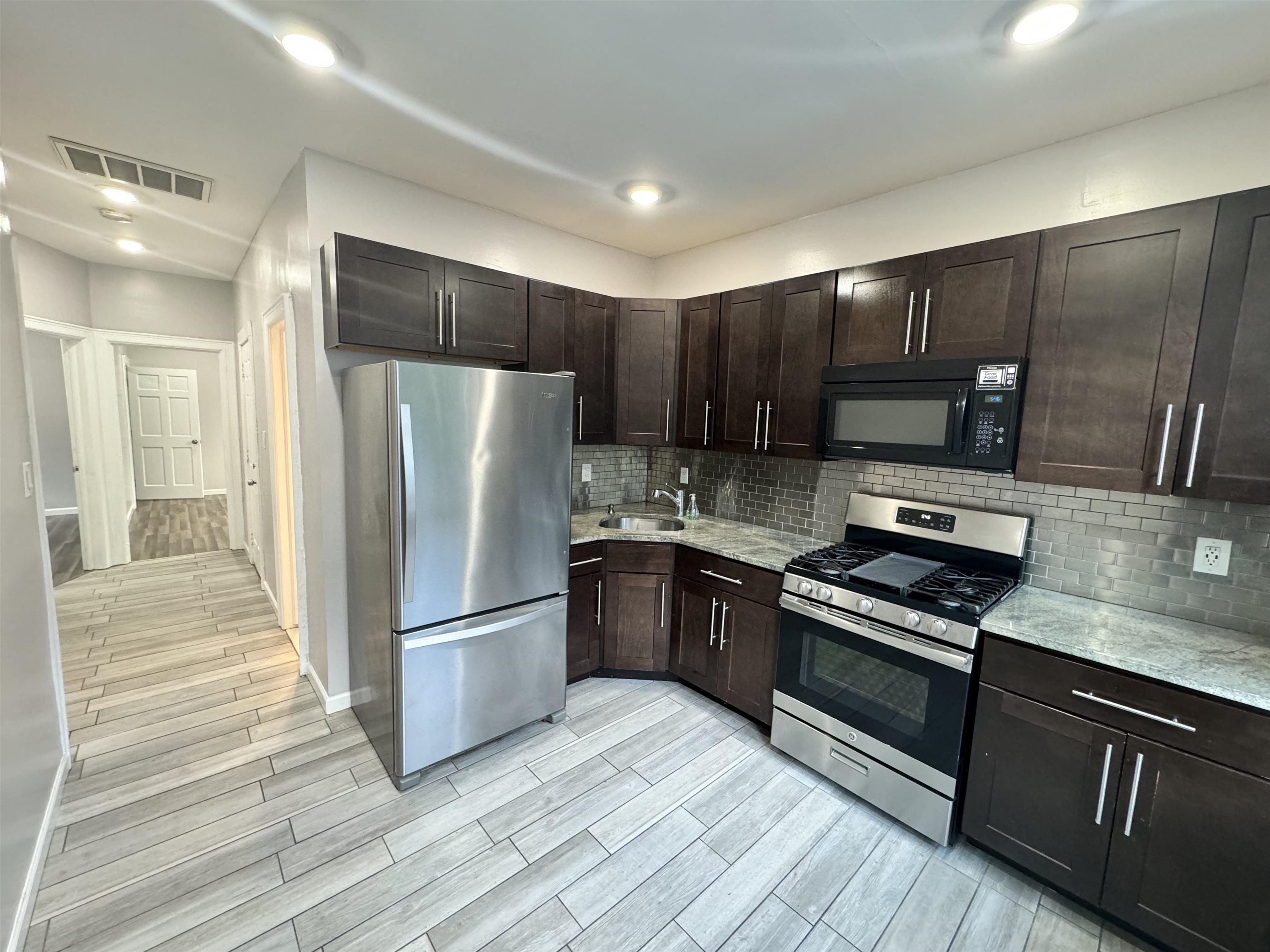 a kitchen with wooden cabinets and stainless steel appliances