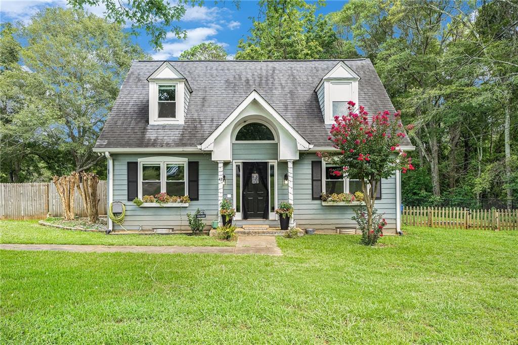 a front view of house with a garden and trees