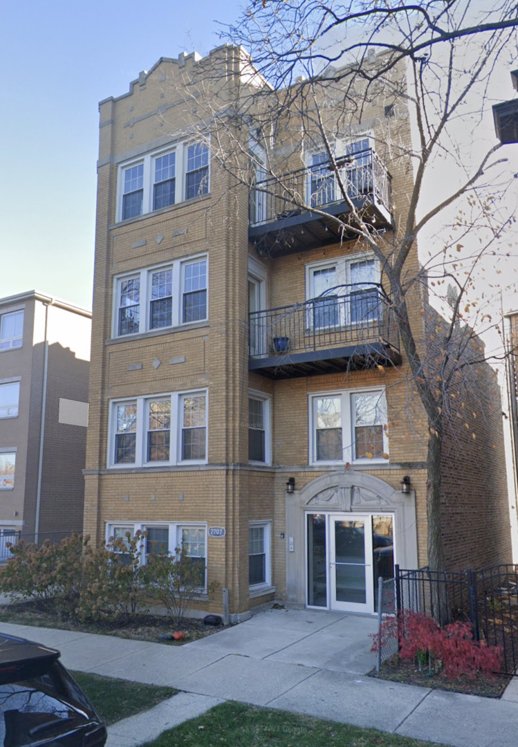 a front view of a residential apartment building with a yard