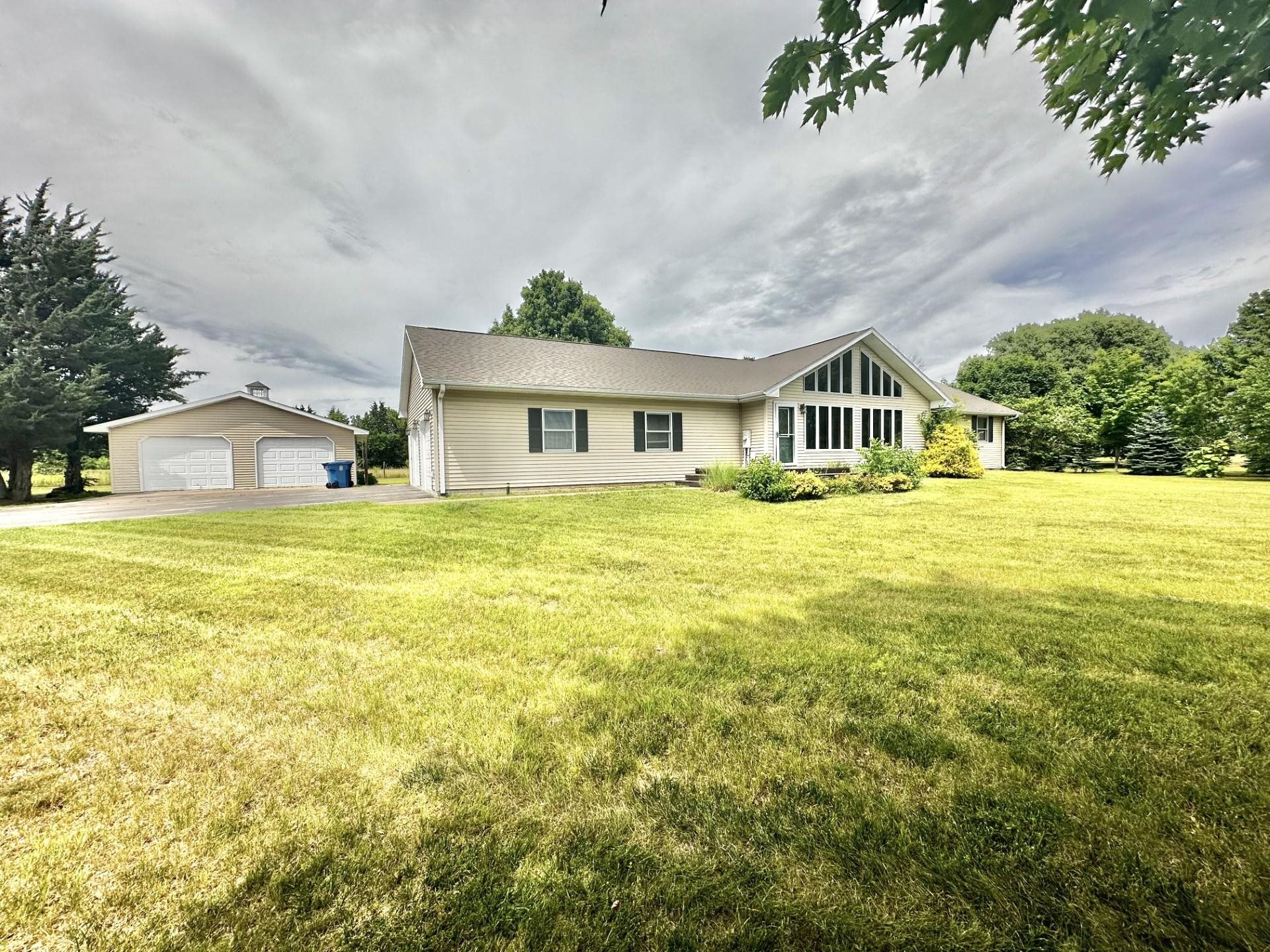 a view of a house with a big yard and large trees