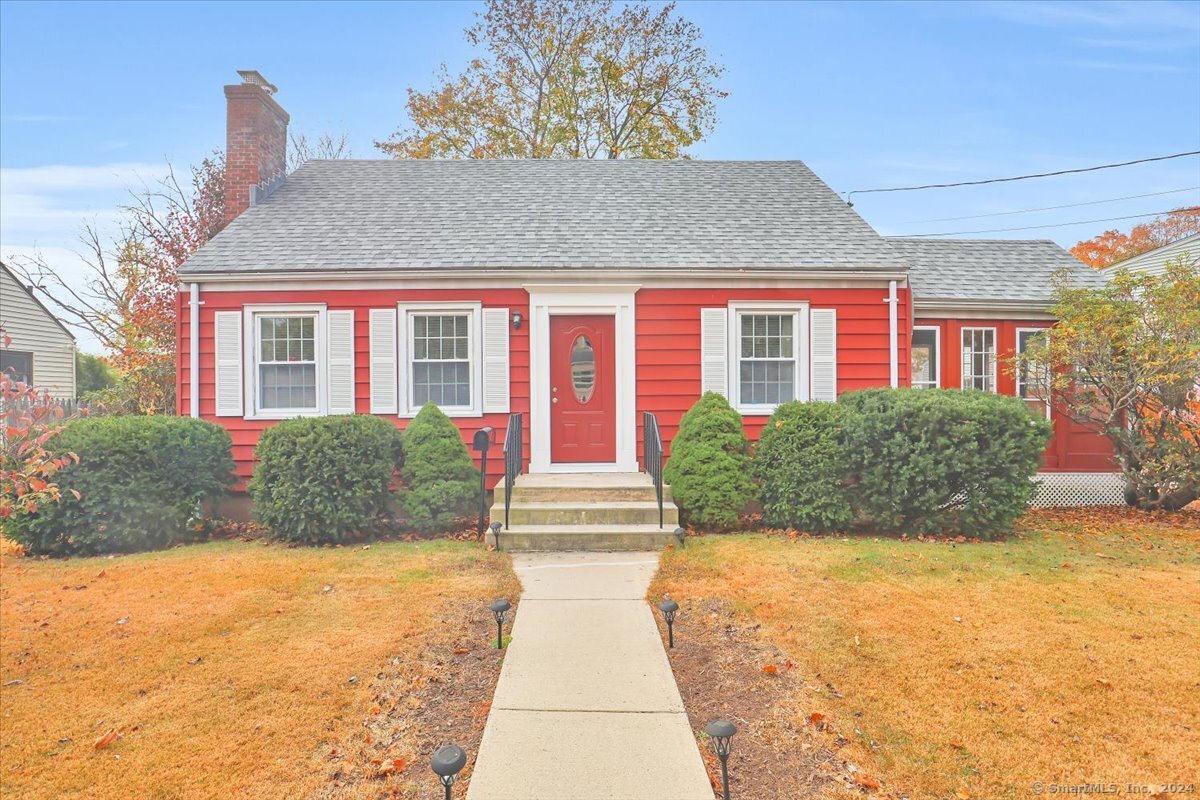 a front view of a house with a yard and potted plants