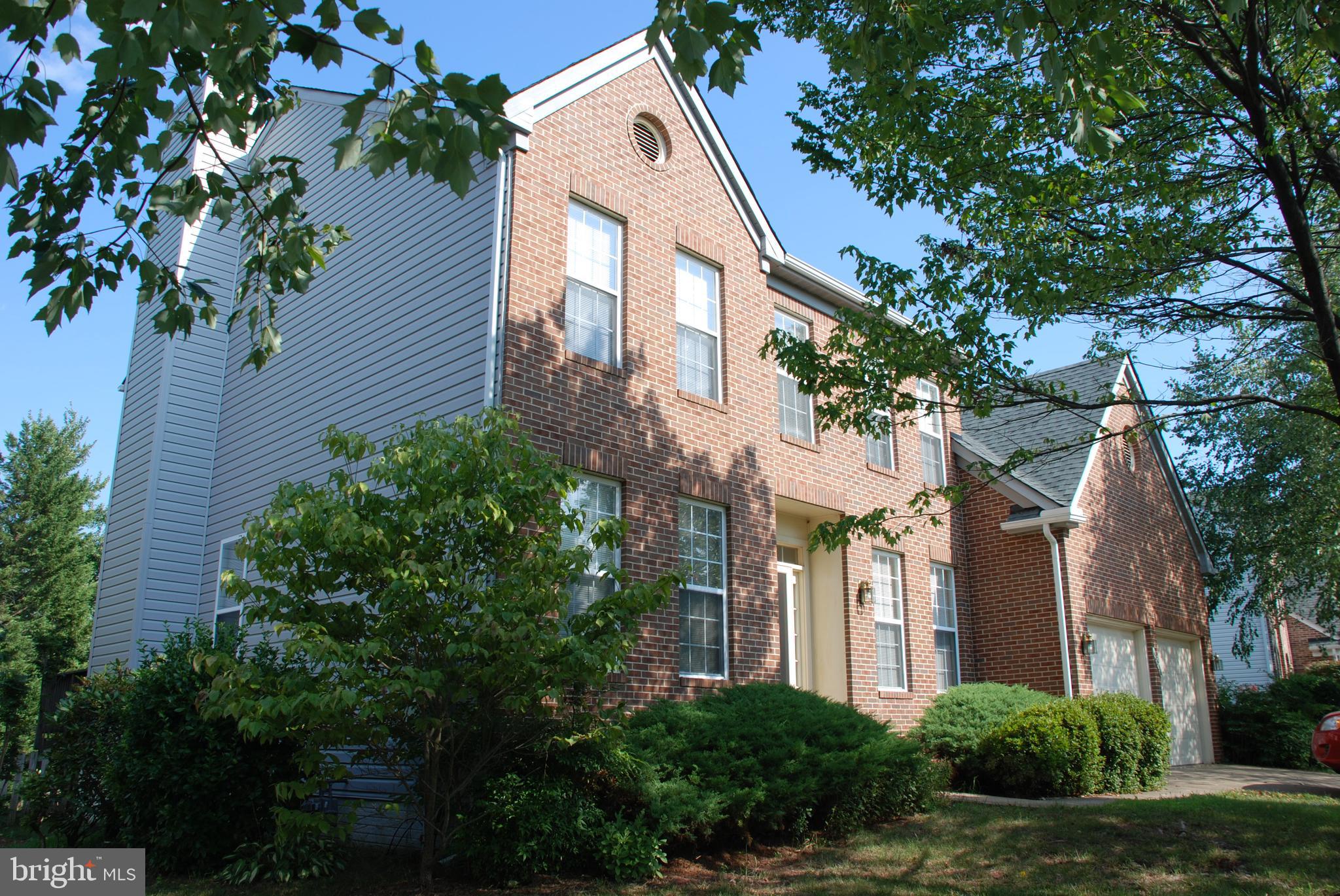 a front view of a residential houses with yard and green space