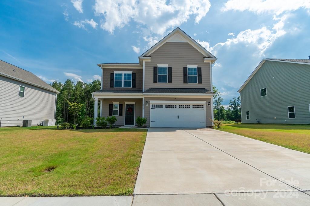 a front view of a house with a yard and garage