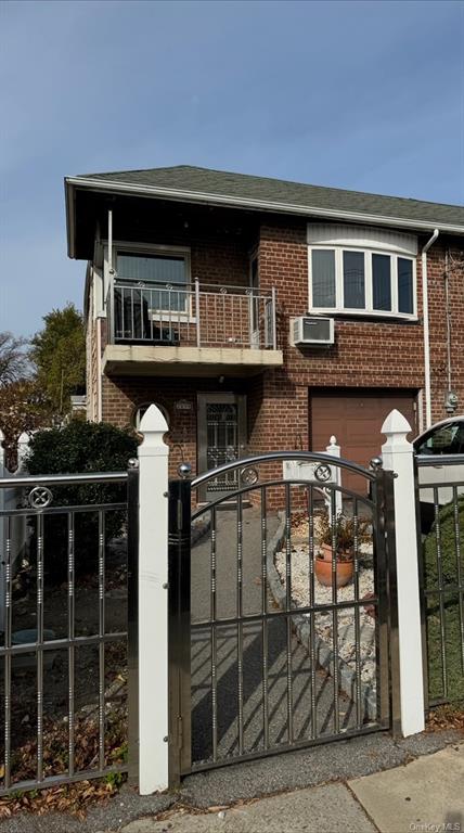 View of front of property featuring a balcony and a garage