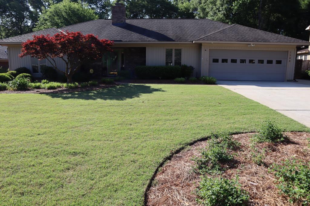 a front view of house with yard and green space