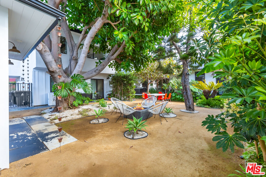 a view of backyard with a table and chairs and potted plants