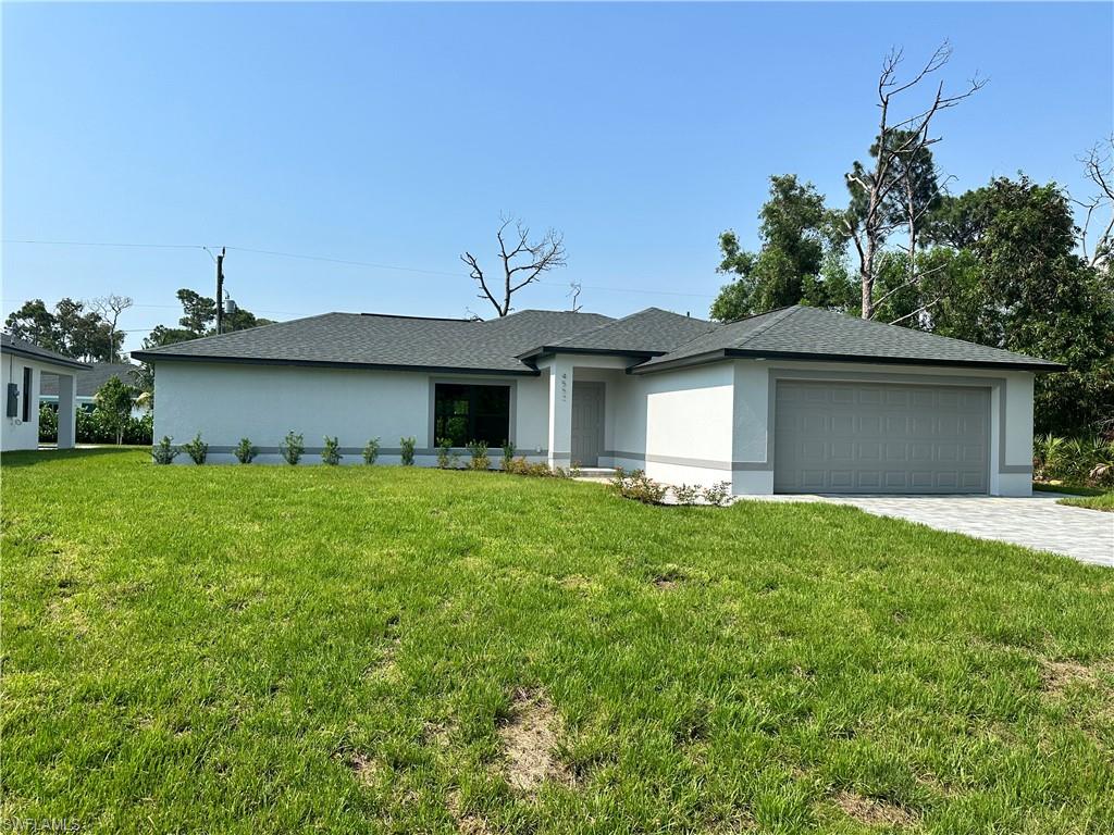 View of front of home featuring a garage and a front yard