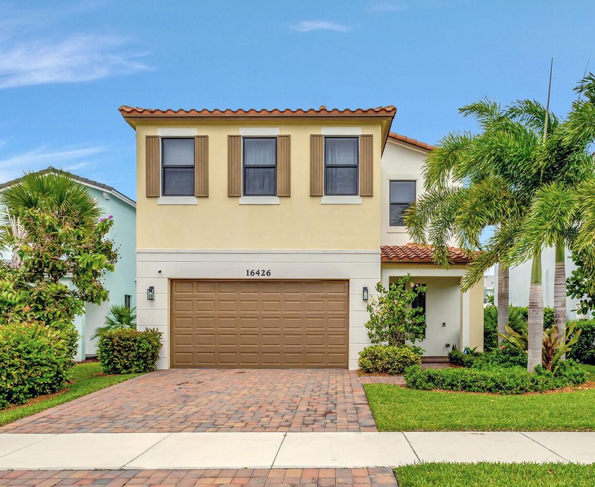 a front view of a house with a yard and a garage