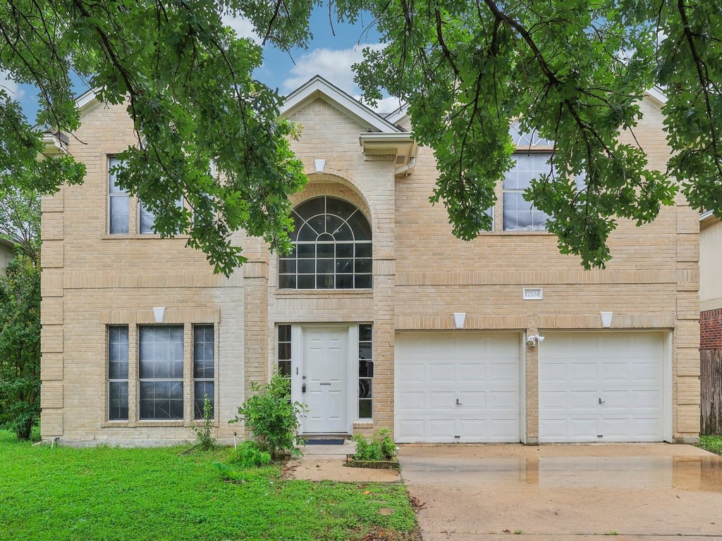 front view of a house with a yard and an trees