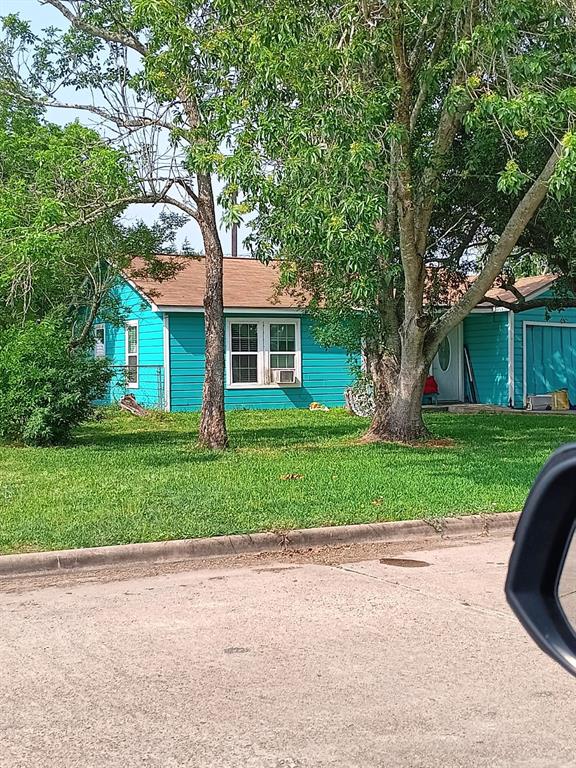 a front view of a house with a yard and trees