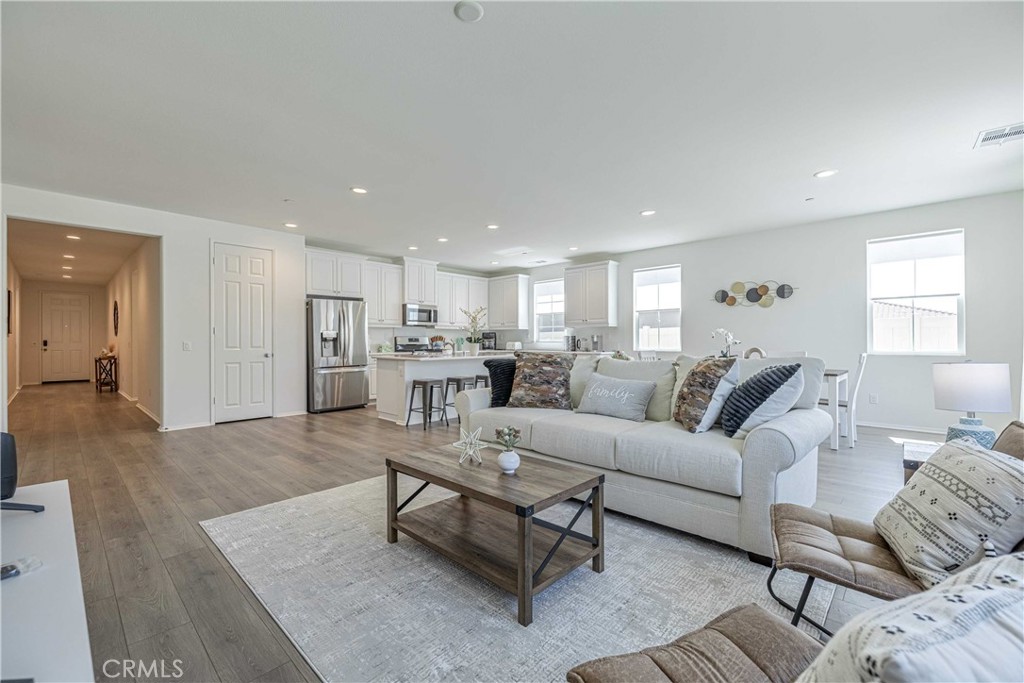 a living room with furniture and view of kitchen