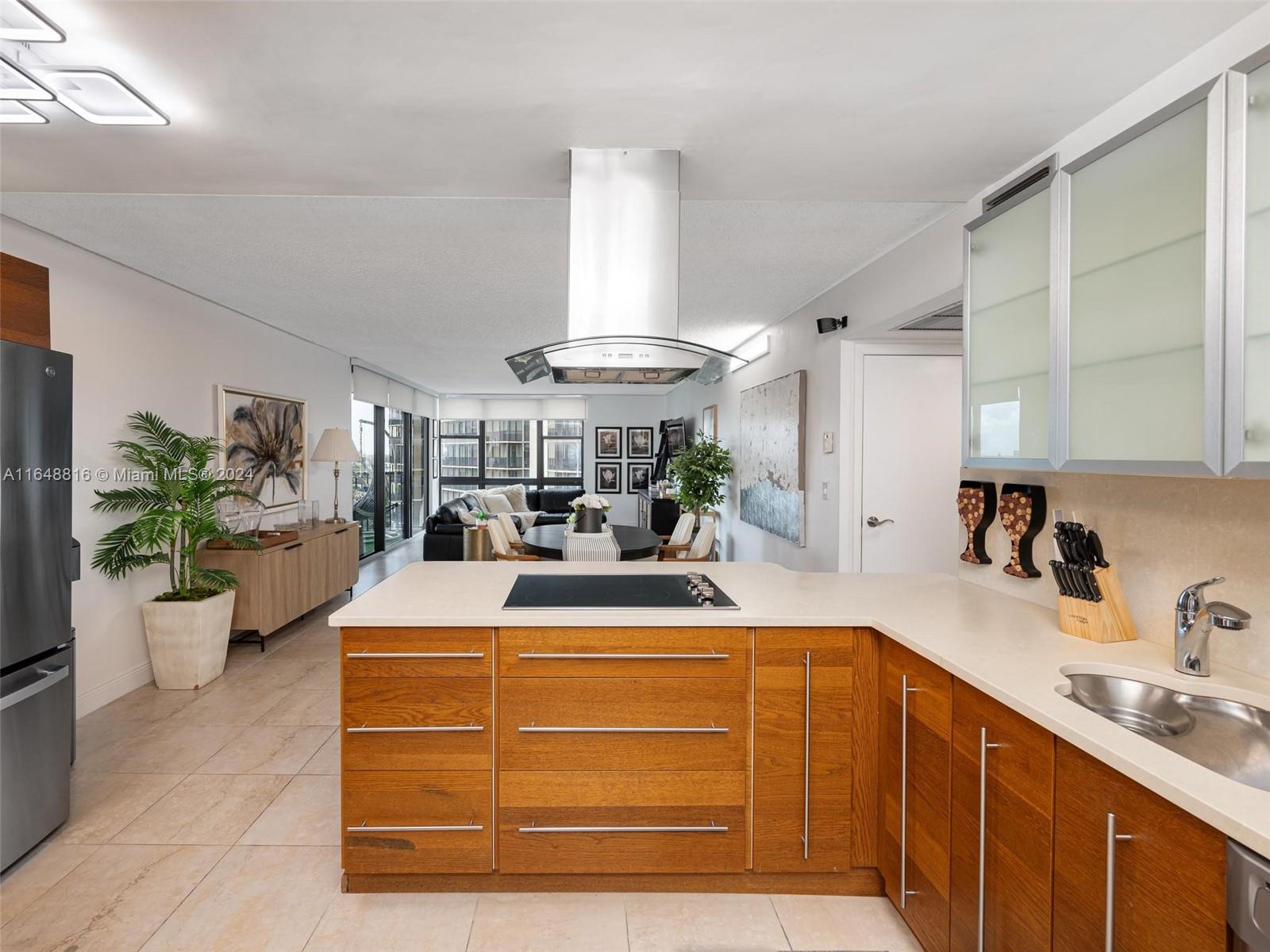 a view of a kitchen with kitchen island a sink stainless steel appliances and living room view