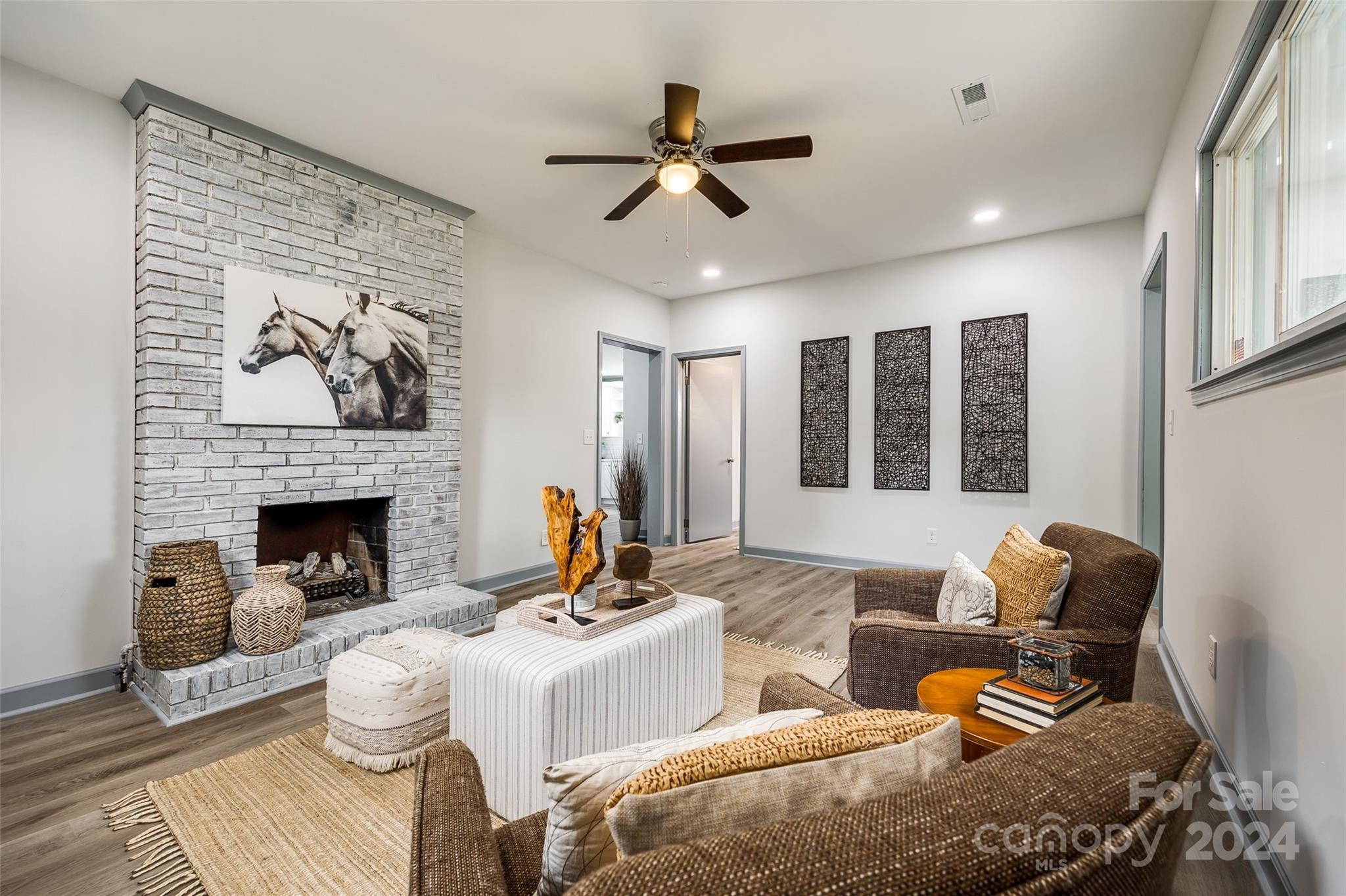 a living room with furniture chandelier and a fireplace