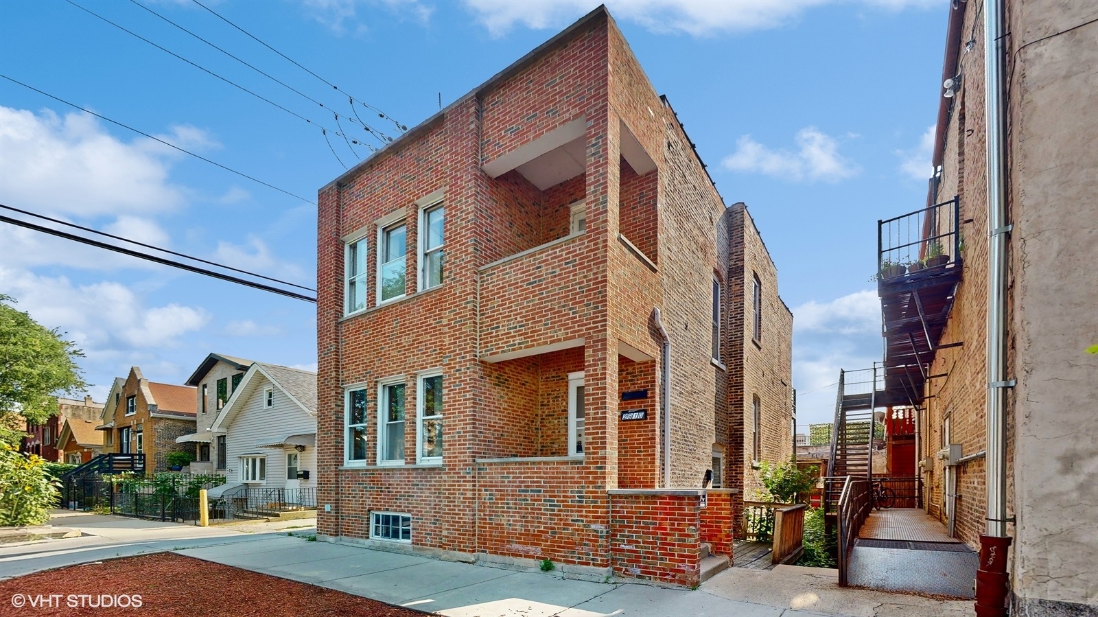 a view of a brick house with many windows next to a road