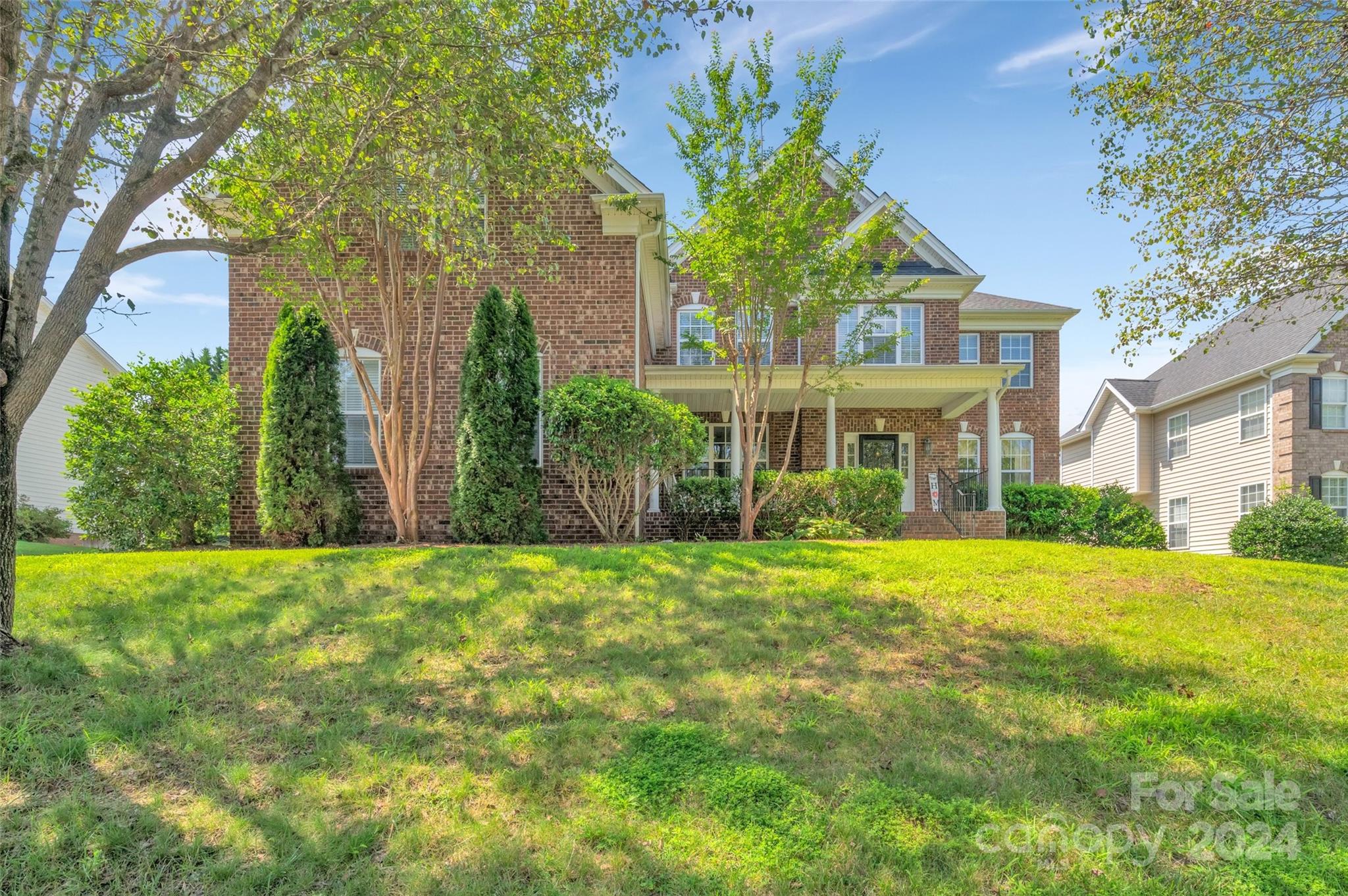 a front view of a house with a yard and trees