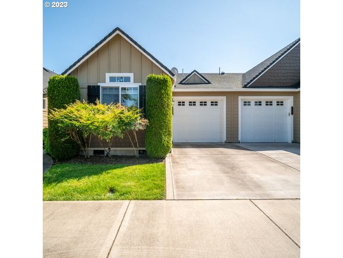 a view of a house with a yard and potted plants