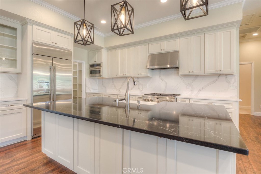 a kitchen with stainless steel appliances granite countertop a sink a stove and cabinets