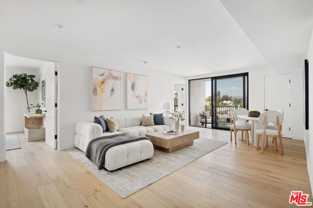 a living room with furniture potted plant and a large window