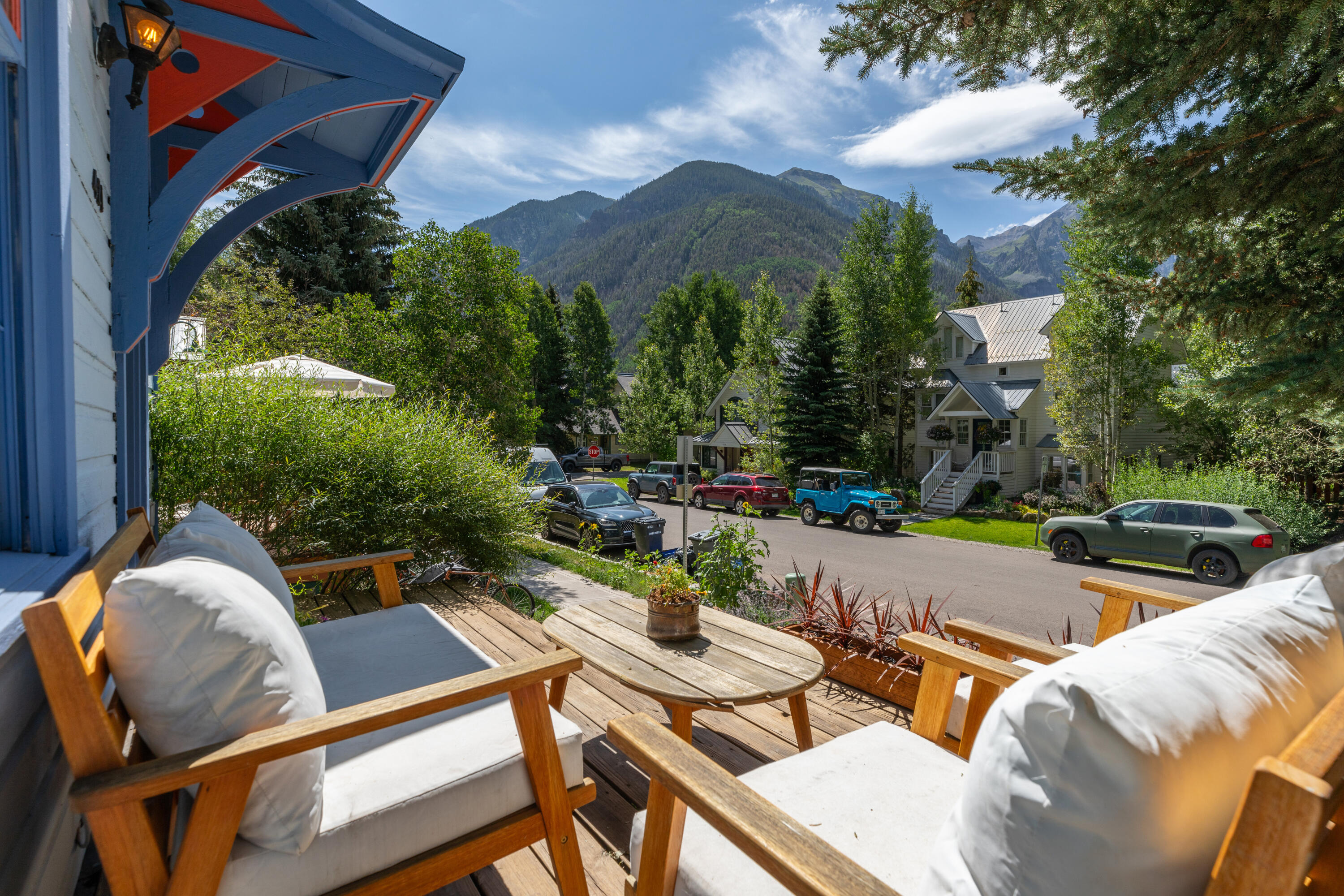 a view of a patio with couches table and chairs under an umbrella with a fire pit