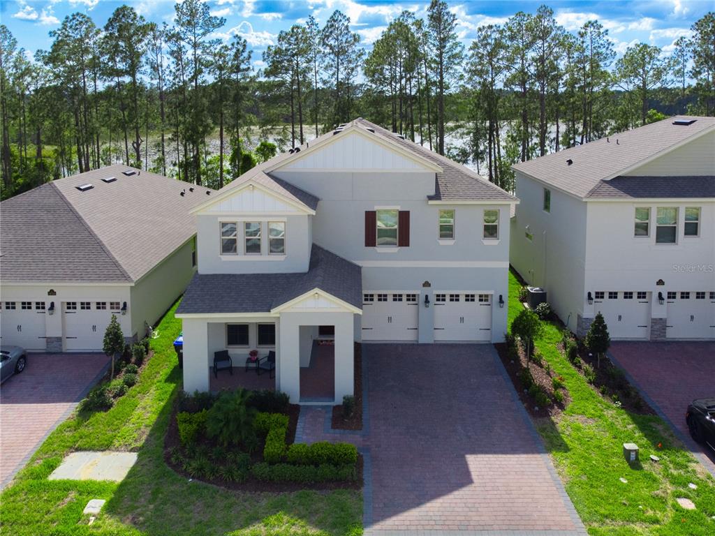 a aerial view of a house next to a yard and large trees